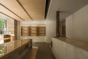 Modern kitchen with wooden cabinets and shelves, well-lit with natural light from windows