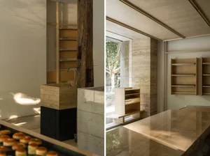 Clean and organized bathroom with a sink in one corner and a shower area, featuring bottles and a book