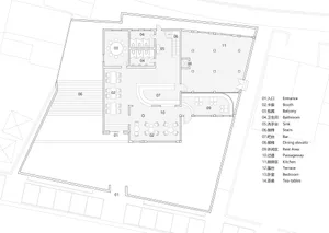 Black and white floor plan of a hotel with various rooms, including a lobby and dining area, featuring concrete and wood materials
