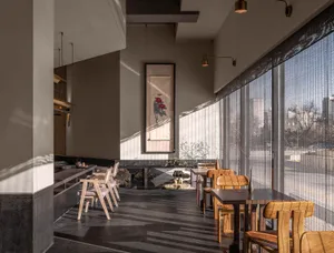 Warm and inviting restaurant interior with wooden tables and chairs, modern design, and cozy atmosphere