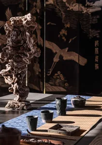 an oriental interior design featuring a wooden table with several bowls and a vase, blending traditional and modern elements
