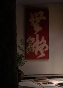 Dimly lit room with a red wall featuring Chinese characters, two potted plants, and a blend of traditional and modern design elements