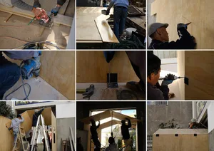 Construction workers on a wooden wall, observing and working on the panels, collaborative atmosphere