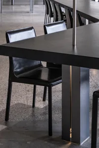 Empty modern dining space with a metal table and leather chairs in a contemporary setting