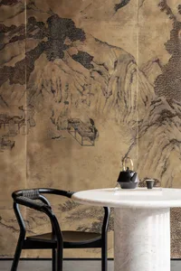 Dining room with a marble table surrounded by chairs, artwork on the walls, and a cozy atmosphere