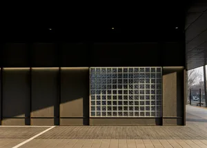 Modern building with a large glass window featuring a checkered pattern, set against a clean and minimalistic backdrop