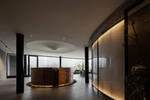Elegant dining space with a circular table, chairs, and two dining tables, featuring a modern design with wood and glass elements