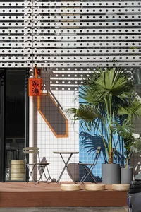 A relaxed outdoor dining area with a wooden table and metal chairs, surrounded by a patio setting
