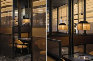 A modern restaurant with a seating area featuring chairs and couches, brown and yellow tones, and natural light