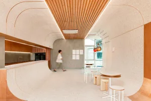 A modern restaurant with wooden floors and walls, featuring chairs and dining tables, with cups scattered around, creating a warm and inviting atmosphere