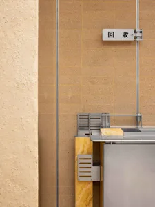 Interior space with a yellow wall, tile floor, and two signs, one with Chinese characters, in a clean and well-organized atmosphere