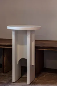 A minimalist room with a unique wooden table and a bench, featuring a clean and simple atmosphere