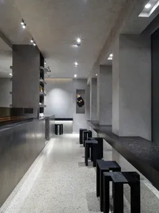 A modern restaurant bar with tile flooring, stools, and chairs in a comfortable seating arrangement