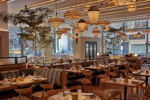 Empty restaurant interior with dining tables, chairs, and wine glasses, creating an inviting atmosphere for customers