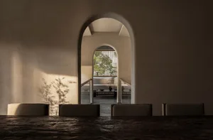 Open living space with two couches, a dining table, and natural light from a window