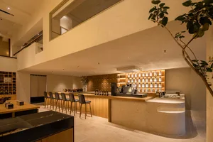 Inviting open kitchen space with wooden floors, white walls, and a dining table surrounded by chairs and bottles