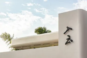Modern building with a white facade, clean lines, and black exterior signs in a contemporary urban setting