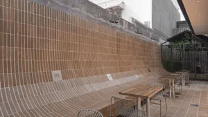 A modern outdoor patio with a dining table and chairs, surrounded by benches, creating a comfortable space for gathering and relaxation