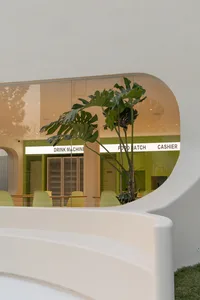 A warm and inviting restaurant bar with a few chairs, potted plants, and a comfortable atmosphere