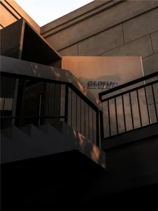 A building with a staircase leading to a second floor, featuring two sets of stairs with railings, and a solid concrete exterior