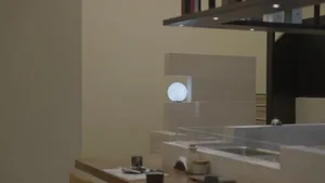 A well-designed kitchen with a sink, countertop, and various decorative items such as cups, bowls, and vases, set against a neutral background