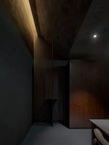 Cozy modern dining room with a wooden table, brown cabinet, and two chairs in a dimly lit space