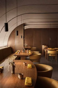 A warm and inviting restaurant interior with wooden tables, chairs, and vases with flowers, creating a cozy ambiance