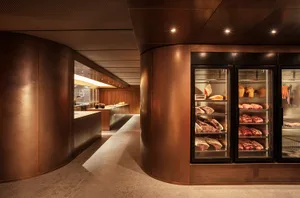 Industrial kitchen with a large refrigerator, bottles, and bowls, set against a neutral background