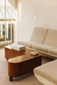 Comfortable living space with couches, a chair, dining table, bookshelf, and natural light from a large window