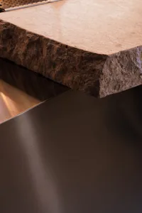 A modern kitchen with a marble countertop, sink, and sleek design
