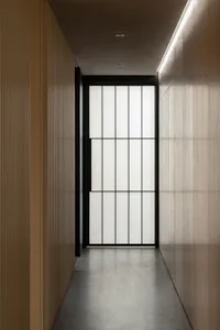 A simple hallway with a black door and glass window, set against a wooden background