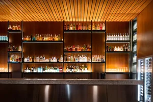 A well-stocked bar with a variety of liquor bottles displayed on shelves behind the counter