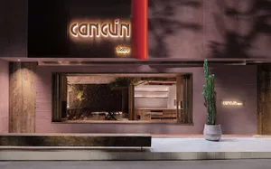 Inviting restaurant interior with red walls, natural light, dining tables, and potted plants