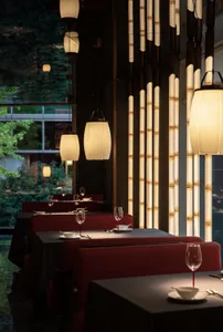 Warm and inviting restaurant interior with red booth seating, wine glasses, and vases, surrounded by comfortable chairs and dining tables