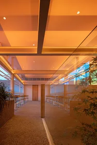A restaurant with multiple dining tables and chairs, creating an inviting and comfortable atmosphere for guests