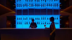 A lively bar scene with a bartender serving drinks to customers, surrounded by bottles and glasses, in a warm and social atmosphere