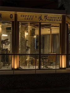 Cozy coffee shop with comfortable seating, artwork on the walls, and natural light from a large window