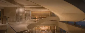 A well-lit dining area with multiple tables and chairs in a modern and elegant space