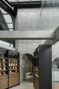 A warm and inviting bookstore interior with a large wooden bookshelf, potted plants, and a cozy atmosphere