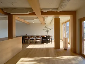Cozy modern dining space with a table surrounded by chairs at various angles, giving off a minimalist vibe