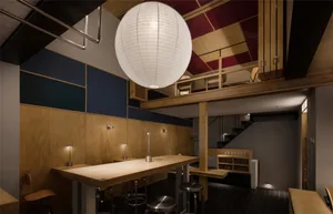 Warm and inviting kitchen space with wooden floors and walls, featuring a dining table and chairs, and a sink on the left