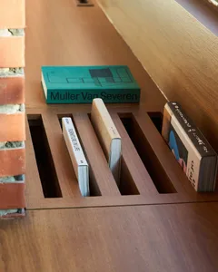 A wooden bookshelf filled with various books of different sizes, creating a cozy and inviting atmosphere in the space