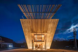 A modern dining space with a wooden structure, warm lighting, and a cozy atmosphere, featuring a dining table and chairs