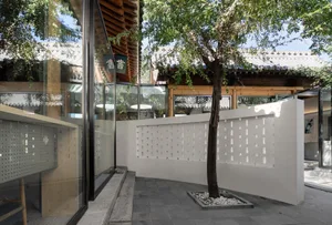 A building with white walls and a tree in front of it
