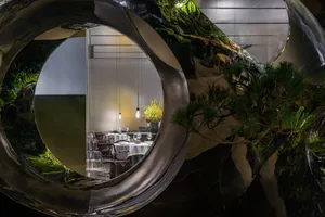 A cozy dining area with a round table surrounded by chairs, wine glasses, and a warm atmosphere