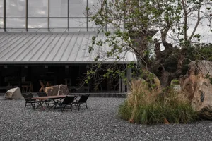 A dining table surrounded by four chairs with black cushions in a comfortable outdoor patio setting