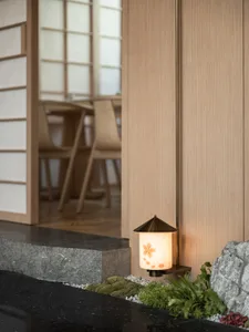 Warm and inviting interior design featuring wooden walls and floors, with comfortable seating and a potted plant adding a touch of greenery