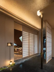 A warm and inviting dining space with a table surrounded by chairs, a large mirror, and a cozy atmosphere
