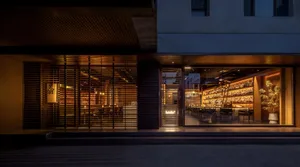 A modern Asian restaurant with a large window, wooden paneling, and comfortable seating for guests