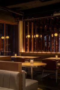 A warm and inviting dining space with wooden tables and chairs, multiple seating options, and a cozy atmosphere
